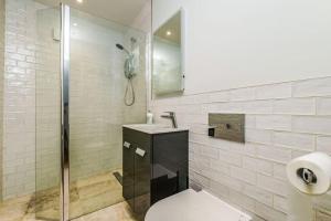 a bathroom with a shower and a toilet and a sink at Hawkers Padstow in Padstow