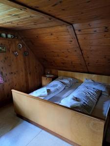 Almzeithütte am Seeberg : سرير في غرفة ذات سقف خشبي