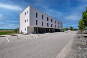 ein großes weißes Gebäude mit Parkplatz in der Unterkunft RELAX PARK Třeboň II in Třeboň