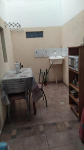 una cucina con tavolo e lavandino in una stanza di Alojamientos MiKa a Puerto Iguazú
