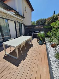 a patio with a white table on a wooden deck at Villa Daniel Saint Aygulf in Saint-Aygulf