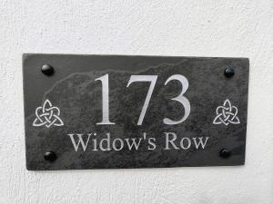 un cartel en una pared con el número. en No. 173 'Widow's Row', en Newcastle