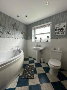 uma casa de banho com uma banheira, um WC e um lavatório. em Corner House - quiet cul-de-sac em York