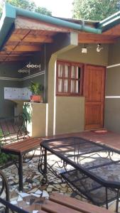 un patio con 2 panche e un edificio con porta in legno di Alojamientos MiKa a Puerto Iguazú