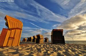 uma fila de cadeiras de praia sentadas na praia em Sommerhaus Glücklich am Meer 2 mit Wellnesszugang em Egmond aan Zee