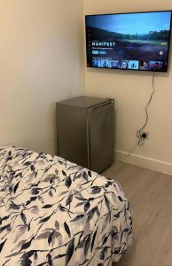 um quarto com uma cama e uma televisão de ecrã plano em PUREWAYS em Southampton