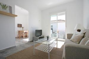 a white living room with a couch and a tv at Casas Karen in Los Caños de Meca