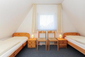 a twin room with two beds and a window at Ferienhaus Am Tief in Neuharlingersiel