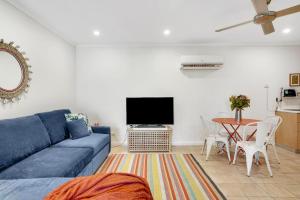 a living room with a blue couch and a table at Boathouse at Iluka Resort Apartments in Palm Beach