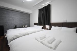 a bedroom with two beds with white towels on them at 東駒形302 in Tokyo