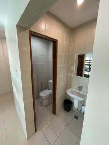 a bathroom with a toilet and a sink at ABE Lodge Taguig in Manila