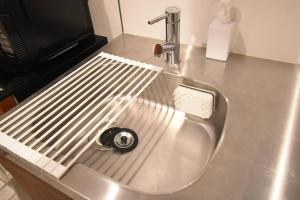 a metal sink with a toothbrush holder on a counter at 東駒形302 in Tokyo