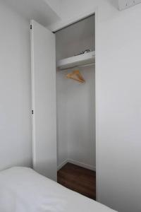 a bedroom with a white bed and a closet at 東駒形302 in Tokyo