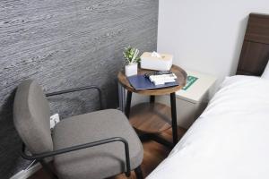 a small table with a chair and a bed in a room at 東駒形302 in Tokyo