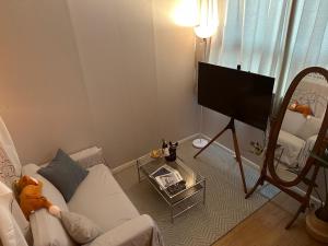 a living room with a white couch and a flat screen tv at DDUBLE Square in Daegu