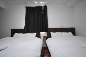 two beds sitting next to each other in a room at 東駒形302 in Tokyo
