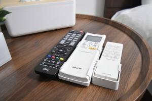 four remote controls sitting on a wooden table at 東駒形302 in Tokyo