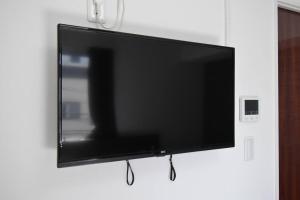 a flat screen tv hanging on a wall at 東駒形302 in Tokyo