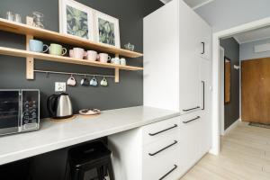 a kitchen with a white counter and a microwave at Apartment with garden Wolkowyska by Renters in Poznań