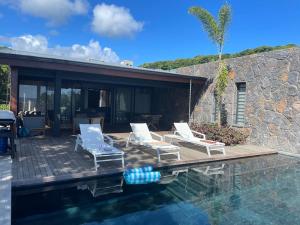 a patio with two chairs and a swimming pool at Villa lagoon view Baie du cap bel ombre in Baie du Cap