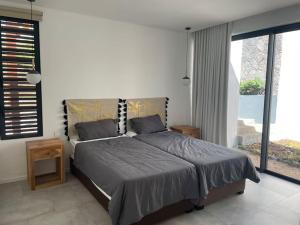 a bedroom with a bed and a large window at Villa lagoon view Baie du cap bel ombre in Ruisseau Créole