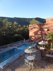 - une piscine avec des tables et des parasols sur une terrasse dans l'établissement Maison d'hôtes tifrit-Paradise valley, à Imouzzer