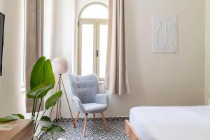 um quarto com uma cadeira e uma janela em Kosnian City Suites em Cidade de Kos