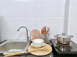 un bancone della cucina con lavandino, pentola e ciotola di Anna House ad Ho Chi Minh