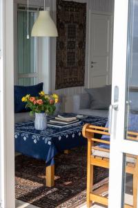 een woonkamer met een tafel met een vaas met bloemen erop bij Arctic Panorama House in Lødingen