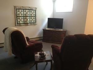 a living room with two chairs and a television at Guest Suites at Willowgreen Farm in Summerside