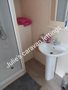 een kleine badkamer met een wastafel en een spiegel bij Julie'scaravan lettings in Kirby Cross