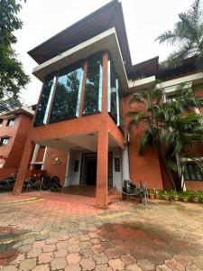 a red brick building with a palm tree in front of it at GD International Redfort in Nilambūr