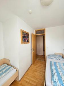 two beds in a room with a hallway at Čandrova koča in Hočko Pohorje