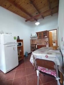 una cucina con tavolo e frigorifero bianco di Alojamientos MiKa a Puerto Iguazú