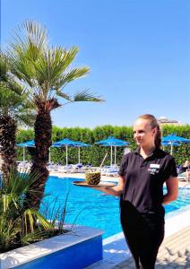 a woman standing in front of a swimming pool at Sveltos Hotel in Larnaca