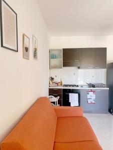 un salon avec un canapé orange dans une cuisine dans l'établissement Anna's HOUSE - Family Home, à Pizzo