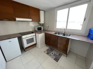 una pequeña cocina con fregadero y microondas en Apartaments Monjardí en Lloret de Mar