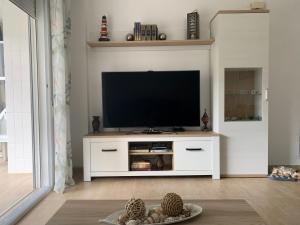 ein Wohnzimmer mit einem TV in einem weißen Unterhaltungszentrum in der Unterkunft Bonito y coqueto apartamento a 150metros de la playa 2 Línea in Playa de Gandia