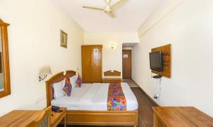 a bedroom with a bed and a flat screen tv at FabHotel Altus in Gurgaon