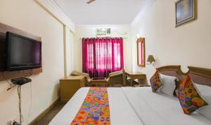 a hotel room with a bed and a television at FabHotel Altus in Gurgaon