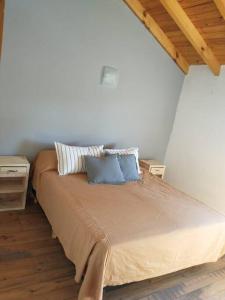 a bedroom with a bed with two pillows on it at Departamento en Junin de Los Andes in Junín de los Andes