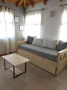 Departamento en Junin de Los Andes في جونين دي لوس أنديس: سرير خشبي مع طاولة في الغرفة