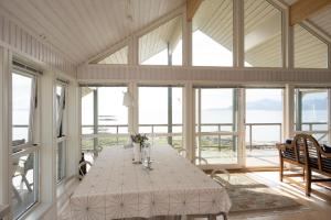 a dining room with a table with flowers on it at Arctic Panorama House in Lødingen