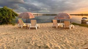 un grupo de sillas y sombrillas en una playa en Lawendowa Przystań WICKO 3 km od Międzyzdrojów, en Międzyzdroje