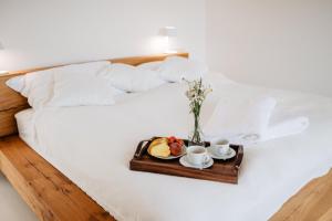 a tray of food and two cups of coffee on a bed at REZAVY in Mikulov