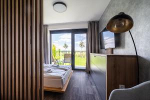 sypialnia z łóżkiem i dużym oknem w obiekcie RELAX PARK Třeboň II w Trzeboniu