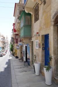 ein Gebäude mit einer blauen Tür und Pflanzen auf einer Straße in der Unterkunft SPQR Studios 2 Valletta in Valletta
