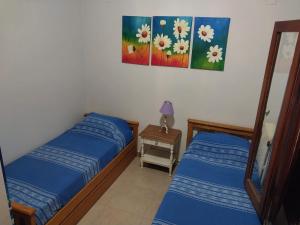1 dormitorio con 2 camas y mesa con lámpara en Casa Ayacucho en Villa Carlos Paz