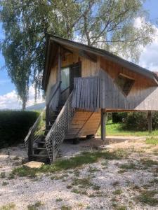 a small house with a staircase in front of it at Nuit insolite - La cabane du Haut-Doubs in Les Gras