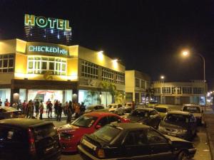 a group of cars parked in front of a hotel at Hotel Checkedinn in Ipoh